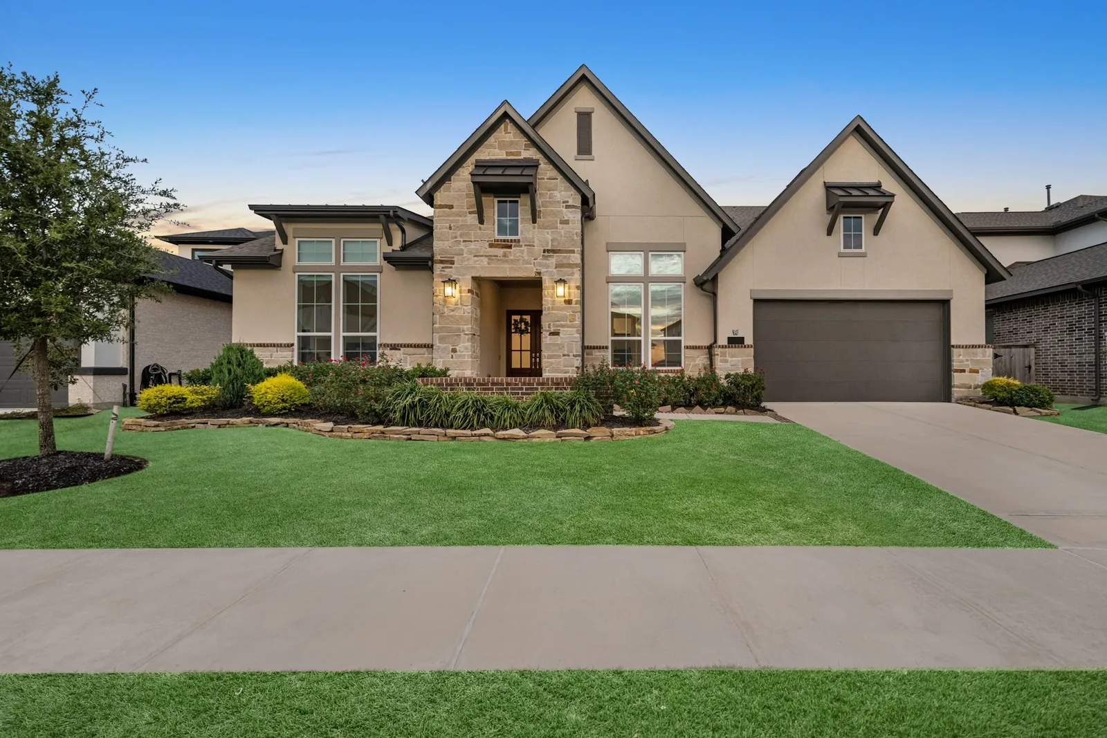 Before: daytime photo of a two-story stone-front home with a front lawn